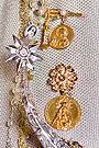 Medallas en la saya de Nuestra Señora del Rosario (Ermita de la Yedra)