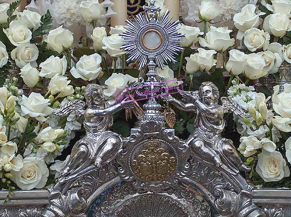 Dos pequeños angelitos portando una custodia en el respiradero frontal del Paso de Palio de María Santísima de la Candelaria