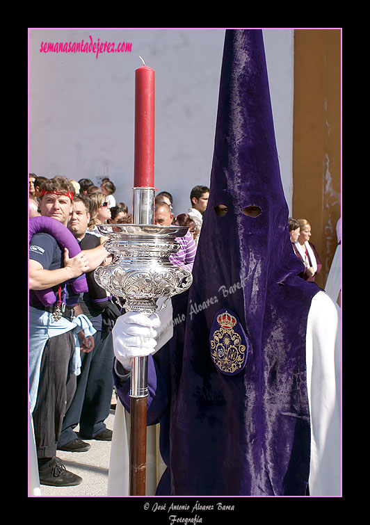 Nazareno con portavelas acompañando al Estandarte Sacramental de la Hermandad de la Candelaria