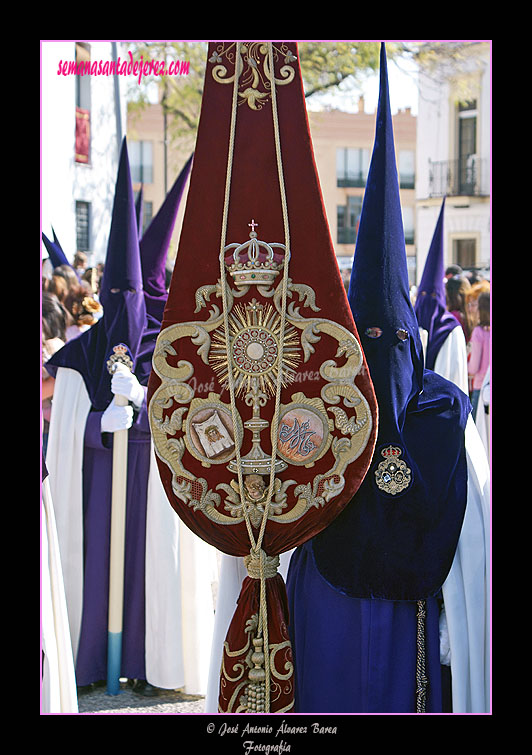 Nazareno portando el Estandarte de la Hermandad de la Candelaria