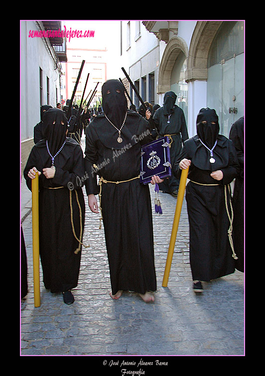 Nazareno portando el Libro de Reglas de la Hermandad de Nuestra Señora de Amor y Sacrificio