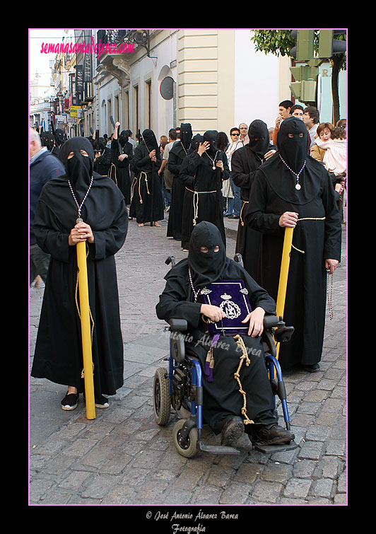 Nazareno portando el Libro de Reglas de la Hermandad de Nuestra Señora de Amor y Sacrificio