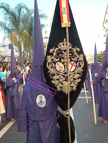 Nazareno que porta el Estandarte de la Hermandad del Cristo de la Defensión