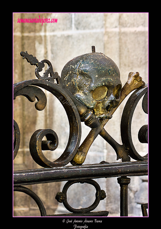 Cráneo con tibia y cetro en la reja del Retablo de Ánimas (Iglesia de San Miguel)