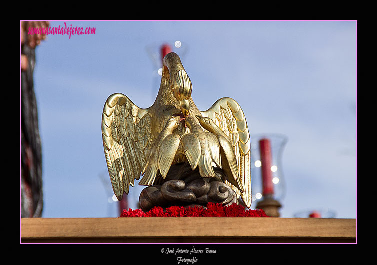 Pelícano dando a beber su sangre a sus crías (símbolo del amor) en el frontal del Paso del Santísimo Cristo de la Sed