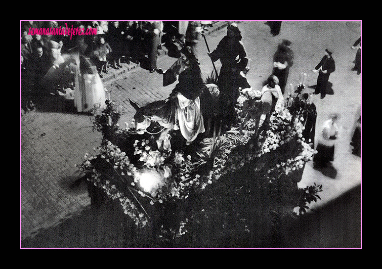 Cristo Rey en su Entrada Triunfal en Jerusalen.Desde 1951 hasta 1957, que estrenó paso, la Estación de Penitencia se hizo con uno que fué de la Hdad. de la Oración en el Huerto. La imagen de San Juan ahora procesiona en Arcos de la Fra., fue cedido a la Hdad. de las Tres Caídas.