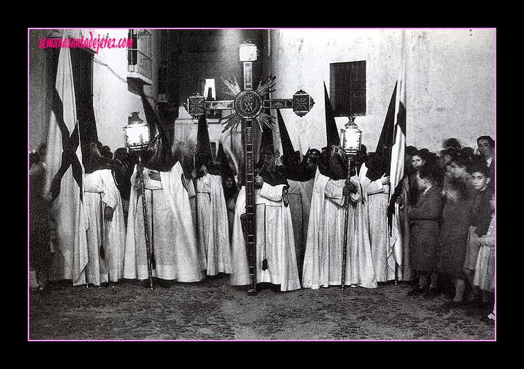 Paso de Misterio de Cristo Rey en una de sus primeras estaciones de penitencia. El paso lo prestaba la Hermandad de la Oración en el Huerto y la imagen de San Juan era la que talló Tomás Chaveli. En 1967 fue sustituida por la de Sebastián Santos Rojas. (Fot.:M.Pereiras, años 1950/55)