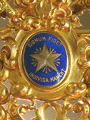 Detalle del escudo de esmalte de los Antiguos Alumnos de La Salle (Indivisa Manent) en la corona de Nuestra Señora de la Estrella