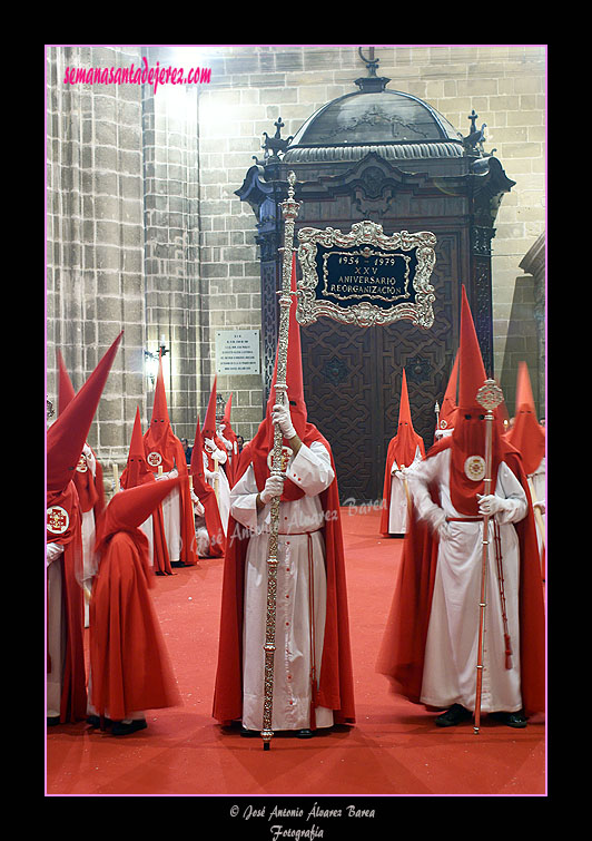 Nazareno portando el Banderín conmemorativo del XXV aniversario de la reorganización de la Hermandad de la Sagrada Cena