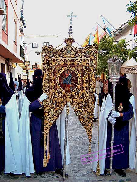 Nazareno que porta el Simpecado de la Hermandad de la Candelaria