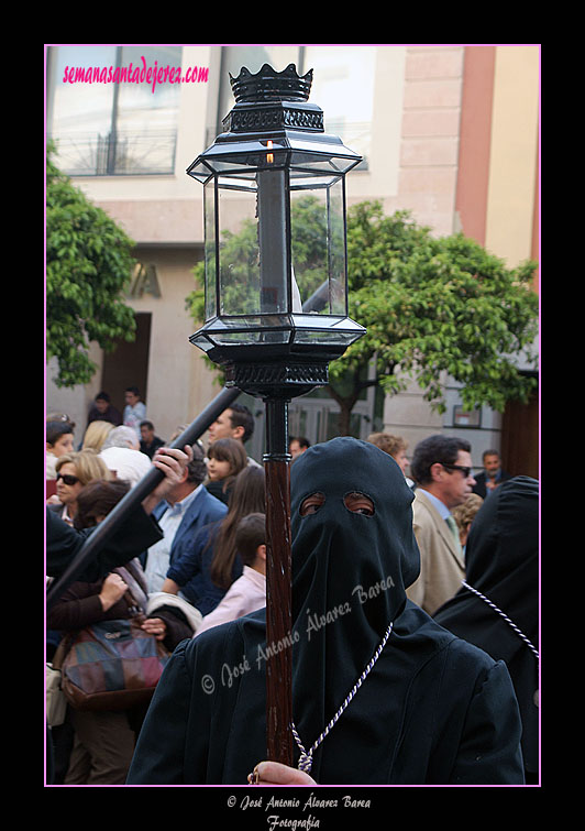 Nazareno con farol de respeto que acompaña a la Cruz de Guía de la Hermandad de Nuestra Señora de Amor y Sacrificio