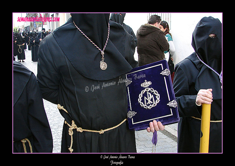 Nazareno portando el Libro de Reglas de la Hermandad de Nuestra Señora de Amor y Sacrificio