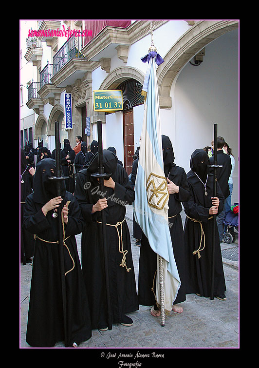 Nazareno portando la Bandera Concepcionista de la Hermandad de Nuestra Señora de Amor y Sacrificio