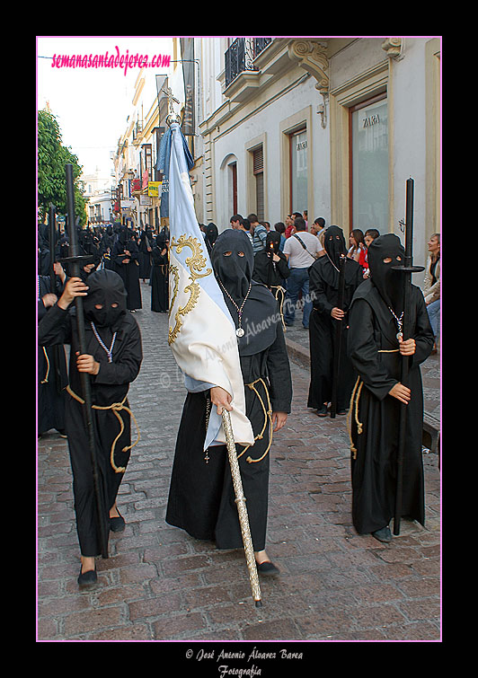 Nazareno portando la Bandera Concepcionista de la Hermandad de Nuestra Señora de Amor y Sacrificio