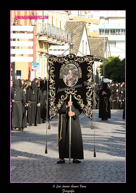 Nazareno portando el Simpecado de la Hermandad de Nuestra Señora de Amor y Sacrificio