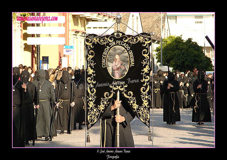 Nazareno portando el Simpecado de la Hermandad de Nuestra Señora de Amor y Sacrificio