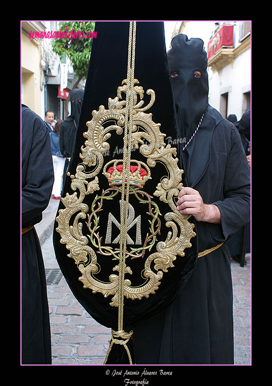 Nazareno portando el Estandarte de la Hermandad de Nuestra Señora de Amor y Sacrificio