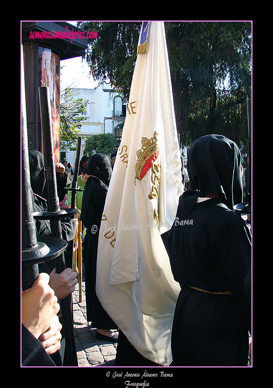 Nazareno portando la Bandera de Devotos de la Hermandad de Nuestra Señora de Amor y Sacrificio