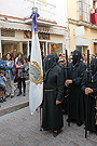 Nazareno portando la Bandera de Devotos de la Hermandad de Nuestra Señora de Amor y Sacrificio