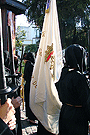 Nazareno portando la Bandera de Devotos de la Hermandad de Nuestra Señora de Amor y Sacrificio