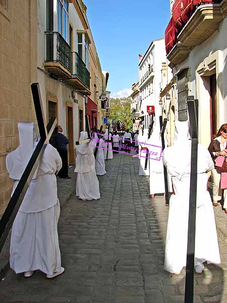 Penitentes con cruces tras el paso del Nazareno Cautivo de la Hermandad del Cristo del Amor