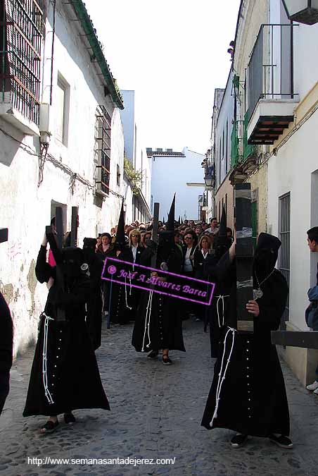 Penitentes tras el paso de Misterio de la Hermandad de Santa Marta