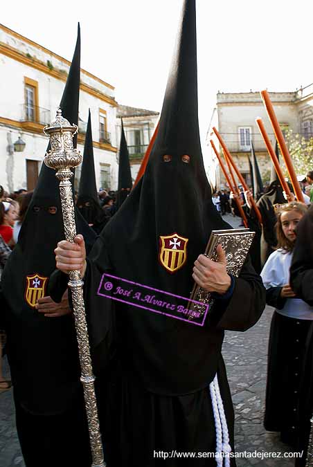 Nazareno portando el Libro de Reglas de la Hermandad de las Tres Caídas