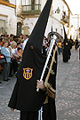 Nazareno portando una bocina de la Hermandad de las Tres Caídas