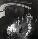 1969. El paso de la Virgen de la Esperanza enfilando la puerta de salida de San Francisco para iniciar la estación de penitencia. En esta foto se ven ya el palio y manto bordados, y sobre la peana la presencia de un ángel pasionario. Al fondo, a la izquierda se ven los faroles del paso del Señor
