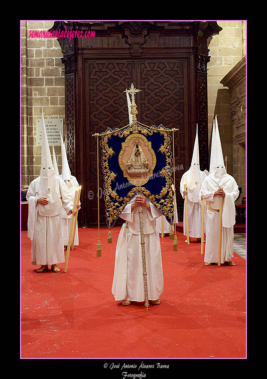 Nazareno portando el Simpecado de la Hermandad de las Cinco Llagas