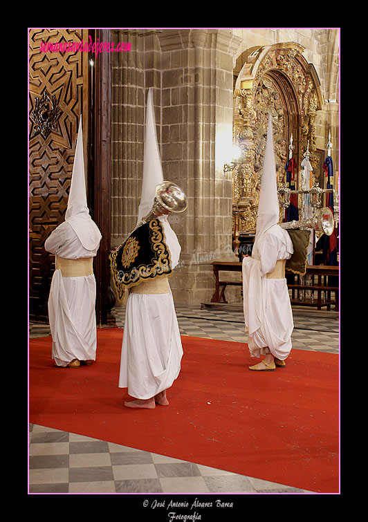 Nazarenos portando bocinas de la Hermandad de las Cinco Llagas