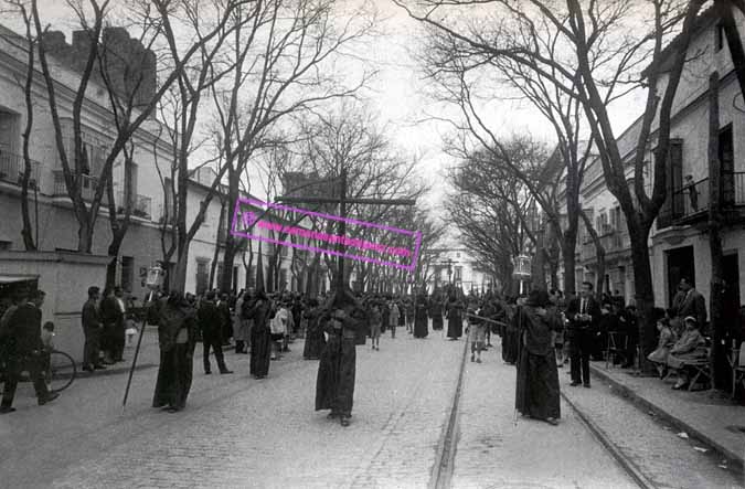 Primera salida procesional de los Nazarenos de la Hermandad del Santísimo Cristo de la Buena Muerte avanzando por la calle Ancha en su camino de vuelta. Pueden verse las antiguas vias de "la maquinilla" que circulaba por esa calle allá por el año 1959 (Foto: Hermandad de la Buena Muerte)