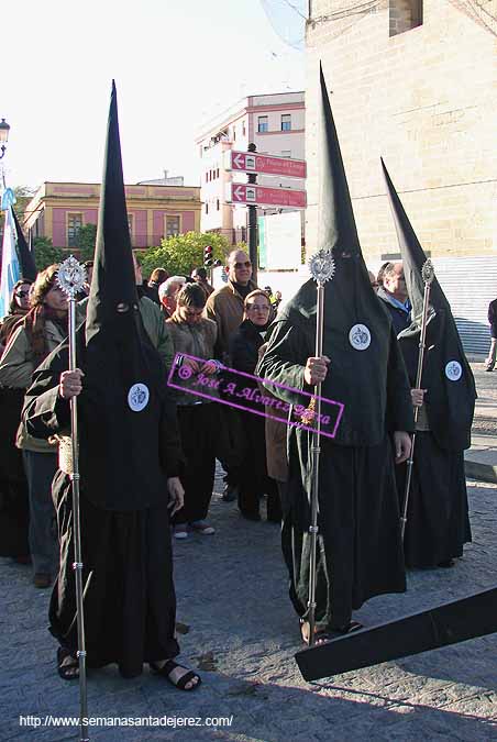 Nazarenos abren paso al cortejo de acompañantes tras el paso de Cristo de la Hermandad del Cristo de la Buena Muerte