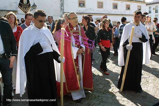 Preste acompañado por dos Acólitos cerrando el cortejo de palio de la Hermandad del Cristo del Perdón