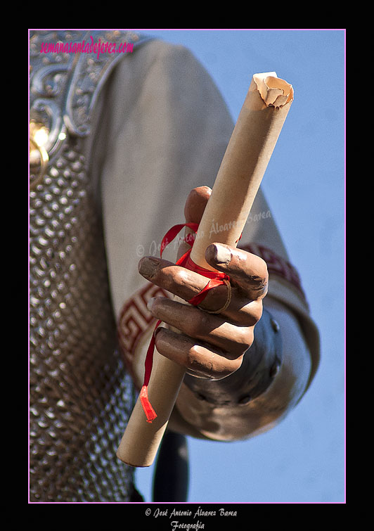 Sentencia de Cristo en la mano izquierda del Centurión romano (Paso de Misterio del Santísimo Cristo de la Exaltación)