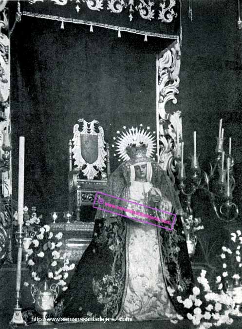 Nuestra Madre y Señora de la Soledad en ceremonia de Besamanos. El manto es el antiguo de corte dieciochesco. Sobre el frontal del dosel aparecen los bordados de mediados de los años 40 del siglo XX de la caida del palio. (Fotografía: Anonima).