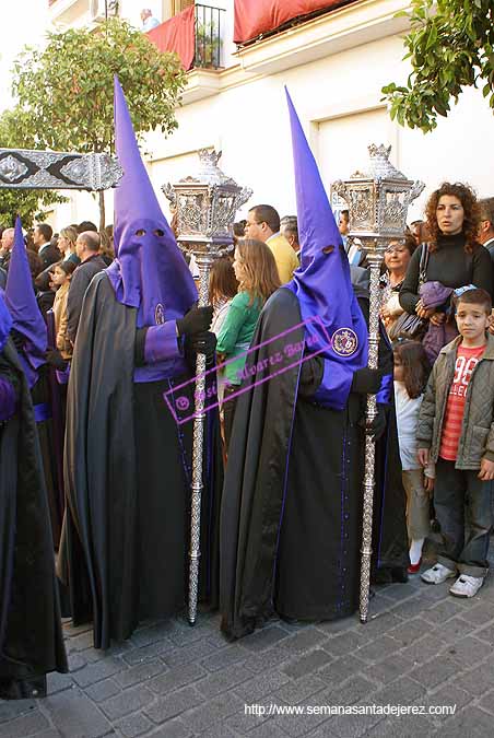 Nazarenos con faroles que acompañan a la Cruz de Guía de la Hermandad de la Soledad