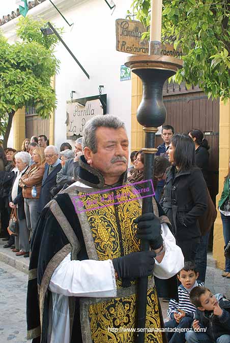 Acólito con cirial que acompaña a la Cruz Parroquial de la Hermandad de la Soledad