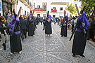 Penitentes con cruces tras el paso de Misterio de la Hermandad de la Soledad 