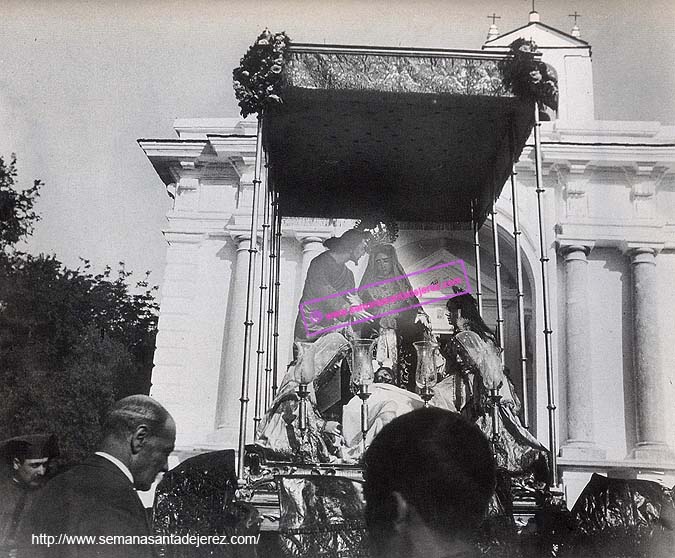 Foto tomada en la explanada que existía delante de la Capilla del Calvario a finales del siglo XIX. La Virgen de la Piedad y el Señor del Santo Entierro, formando un misterio bajo palio, tras la ceremonia del Descendimiento que se realizaba en el Arenalejo de Santiago. Llama la atención la similitud del atuendo de los cargadores con los de la Hermandad del Cristo. (Foto: Diego González)