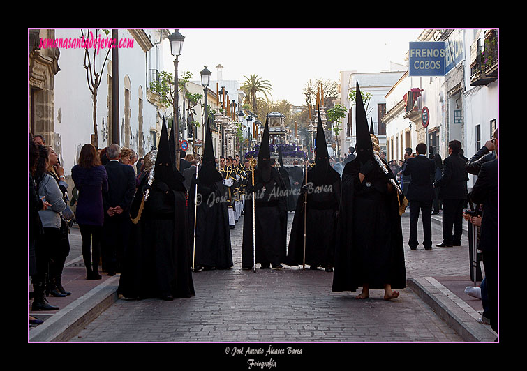 Nazarenos con bocinas y Presidencia del paso de la Urna de la Hermandad del Santo Entierro